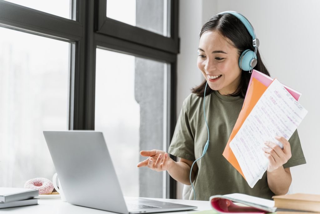Woman with headphones having video call laptop